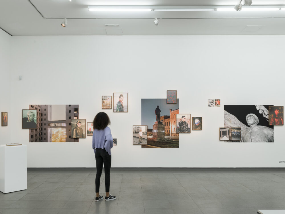 A woman looks at the exhibition gute Aussichten at photographs by Lukas van Bentum