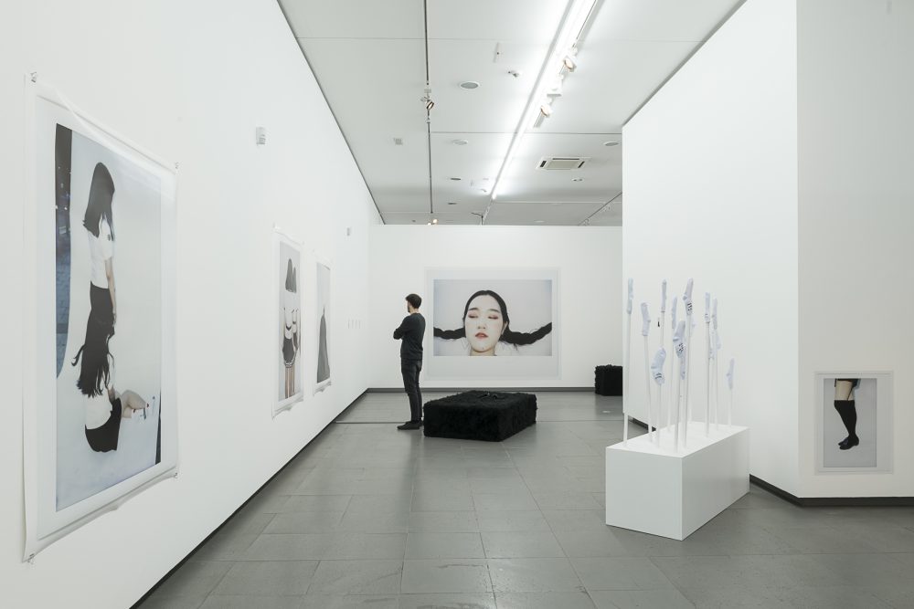 Eine Person betrachtet an der Wand hängende Fotografien in der Ausstellung gute Aussichten im NRW Forum