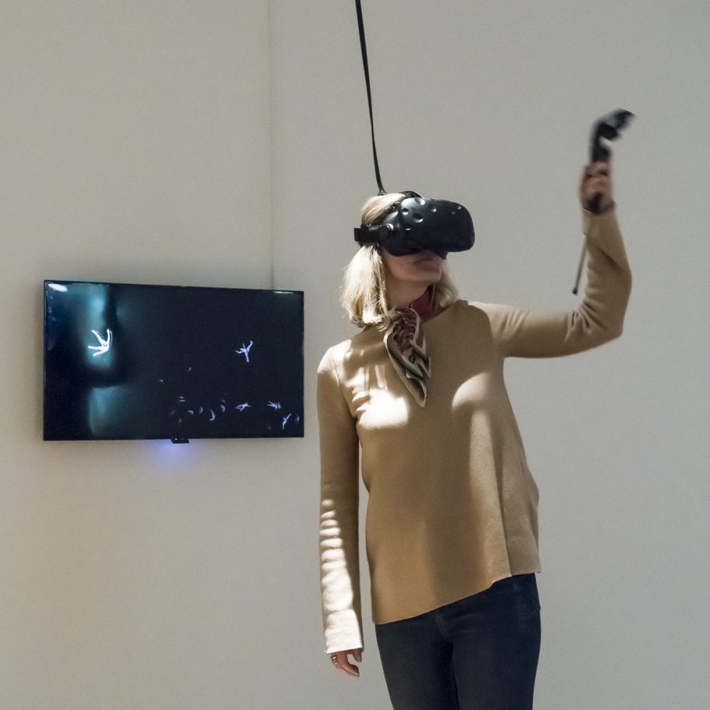 A woman wearing VR glasses in the exhibition Körperwende