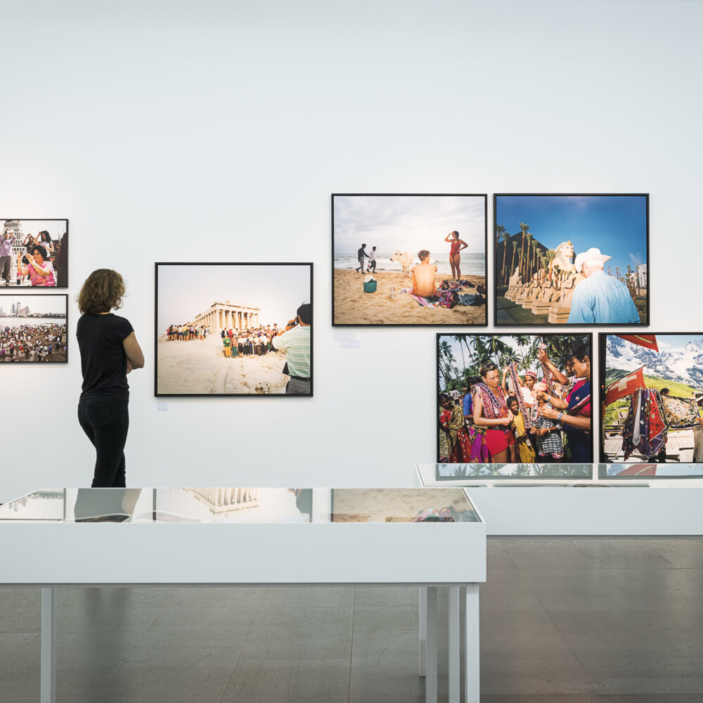 Eine Person betrachtet in der Martin Parr Retrospektive Bilder des Fotografen