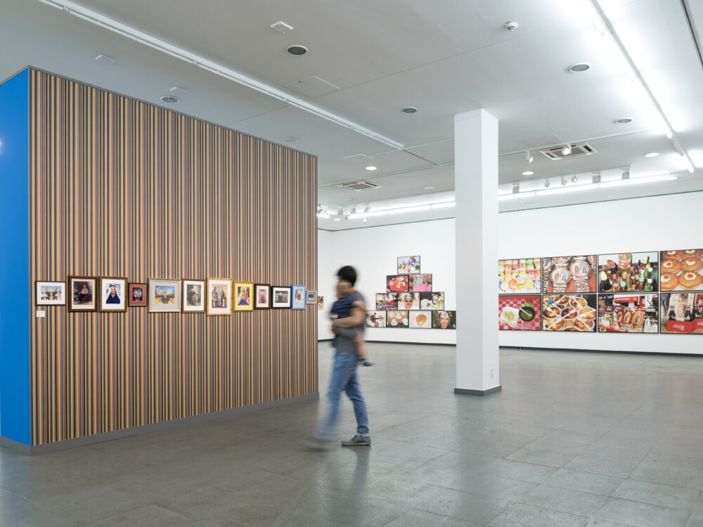 A person in the Martin Parr retrospective looks at pictures of the photographer