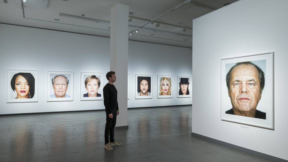 Ein mann betrachtet ein Porträt von Jack Nicholson aus der Serie Close Up in der Ausstellung Martin Schoeller