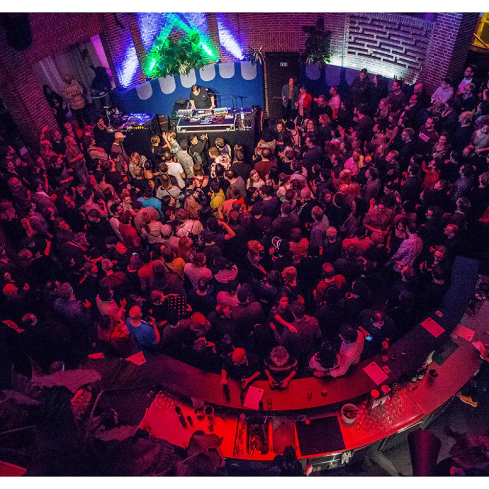 Konzert mit vielen, dicht gedrängten Personen im Publikum sowie ein Musiker auf der Bühne in der Rotunde des NRW Forums