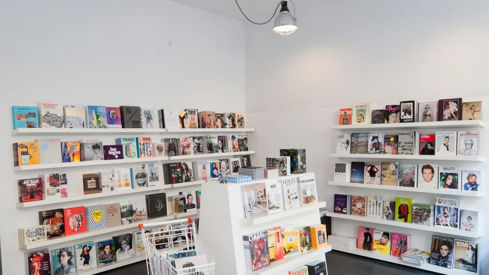 Mehrere weiße Regale mit vielen verschiedenen Büchern und Magazinen