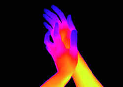 Two touching hands in bright colours, which merge into each other, on black background
