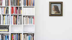 Weißes Regal gefüllt mir Büchern links und ein an der Wand hängendes Gemälde mit Porträt einer jungen Person mit langen Haaren rechts