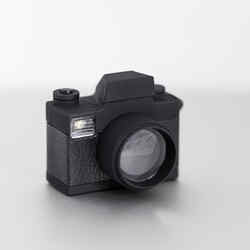 Schwarze Miniaturkamera, bei der sich das Logo des NRW Forums in der Linse spiegelt