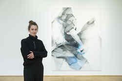 Die Künstlerin Natascha Schmitten steht in der Ausstellung Made in Düsseldorf Nummer 2 vor einem ihrer Gemälde