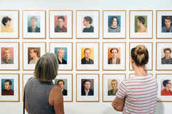 Zwei Frauen betrachten in der Ausstellung Made in Düsseldorf Nummer eins Porträtaufnahmen des Künstlers Thomas Ruff