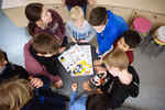 Children stand around a table with a construction set for a vehicle