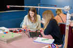 Two teenagers sit at a table and program something on a laptop